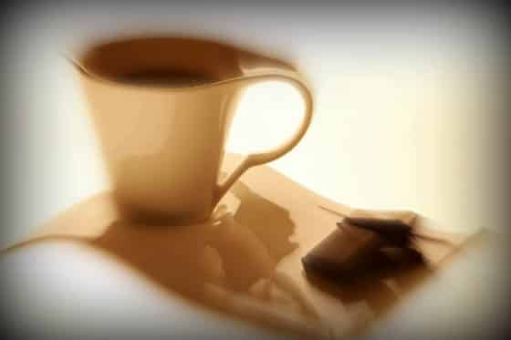 Coffee in cup and chocolate pieces looking blurred to depict addiction. How to End Your Addiction to Chocolate or Caffeine