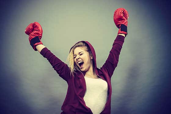 Victorious woman in boxing gloves to demonstrate ways to fight depression.